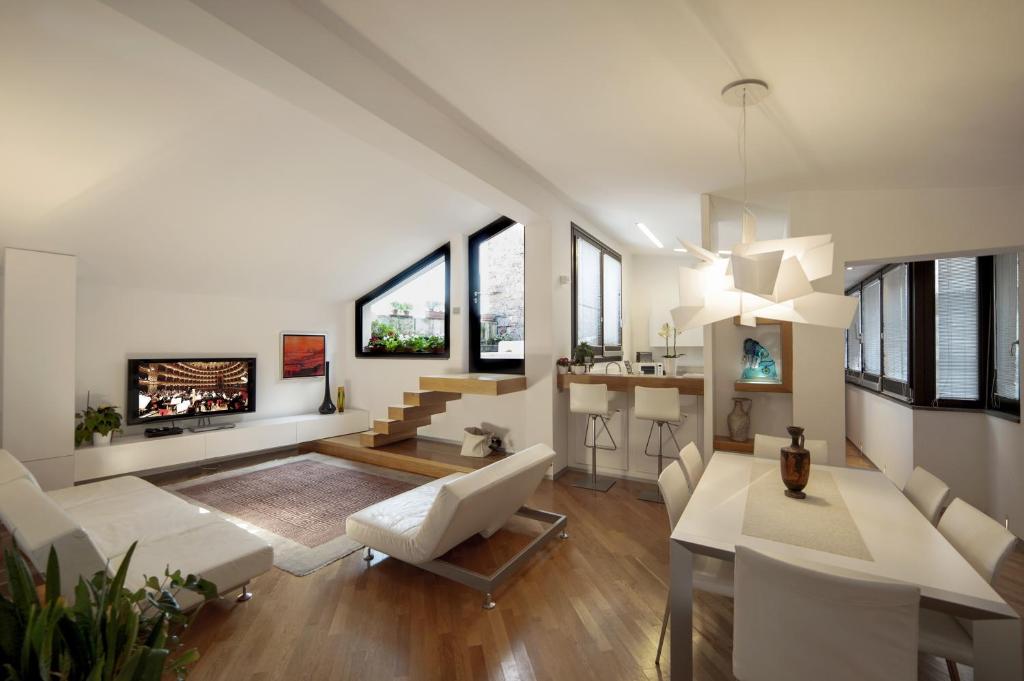 una sala de estar con muebles blancos y ventanas grandes. en Loft In Master Palace, en Catania