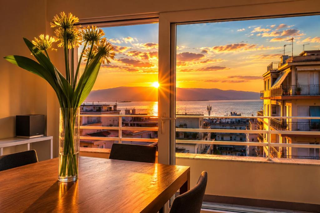 a vase of flowers on a table with a view of the ocean at B&B Pellicano Guest House in Reggio di Calabria