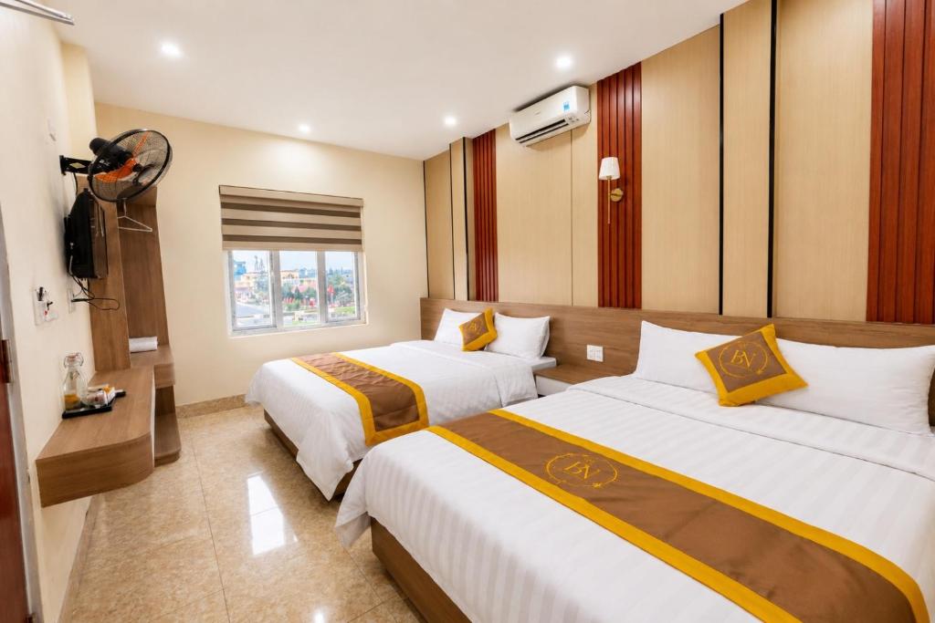 a hotel room with two beds and a television at Bảo Ngọc Cô Tô hotel in Đảo Cô Tô
