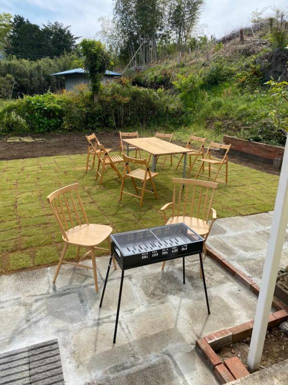 a table and chairs and a piano on a patio at トラストメゾン荻 in Ito