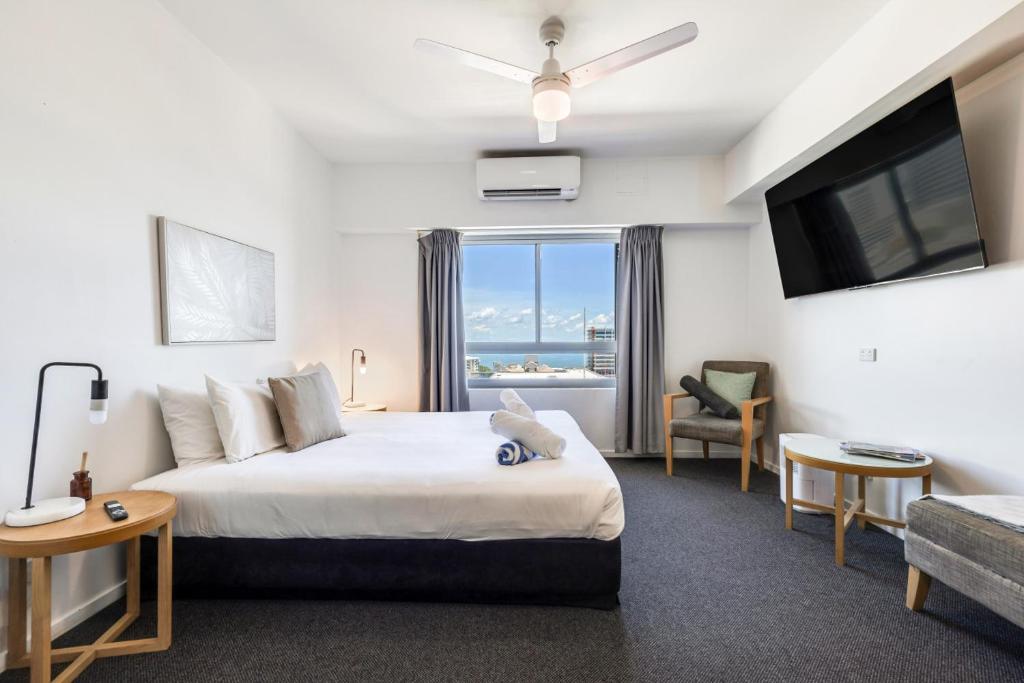 a hotel room with a bed and a large window at 15th Floor Superior Hotel Suite King Bed in Darwin