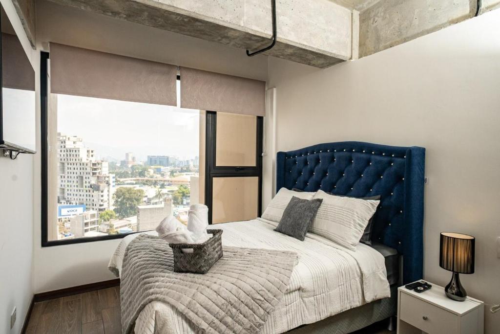 a bedroom with a large bed and a large window at 1503 A - INARA Downtown Four in Guatemala