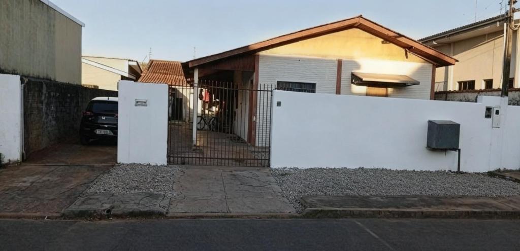 a white fence in front of a house at República Nunes e Silva in Vilhena