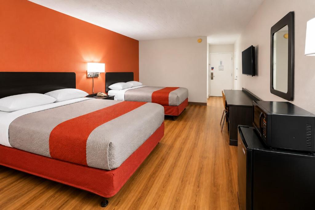 a hotel room with two beds and a flat screen tv at Motel 6-New Stanton, PA in New Stanton