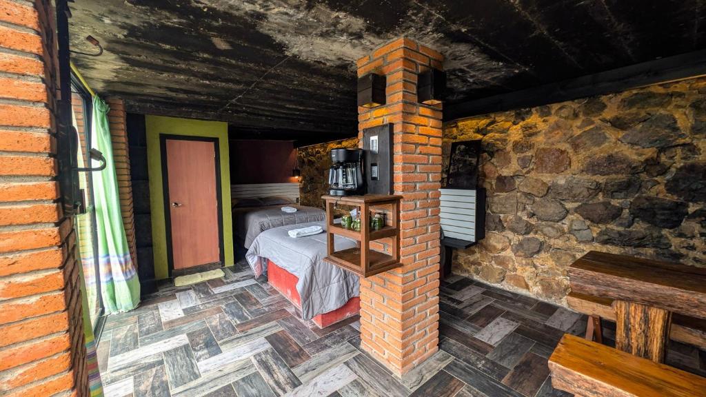 a room with a bed and a brick wall at Habitacion corralito in San Jose del Pacifico