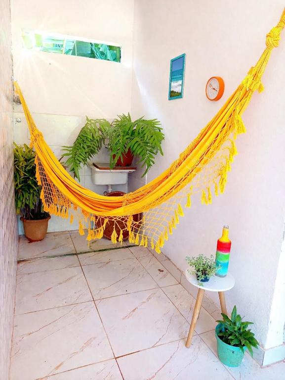 a yellow hammock in a room with plants at Solar das pérolas Búzios 1 in Búzios