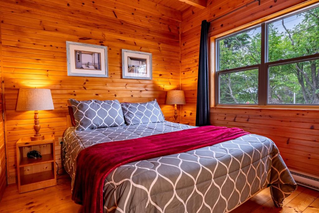 a bedroom with a bed in a log cabin at Avonlea Forest Hill Cottages in New Glasgow