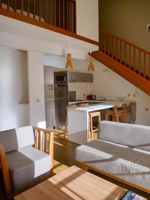 a kitchen and living room with a couch and a table at Le Pacifik Kone in Koné