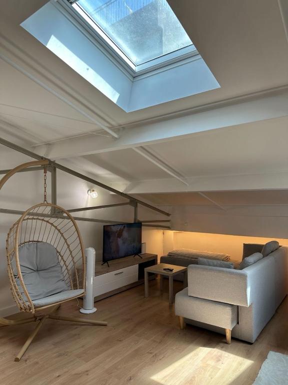a living room with a skylight and a swing at LOFT cosy in Poitiers