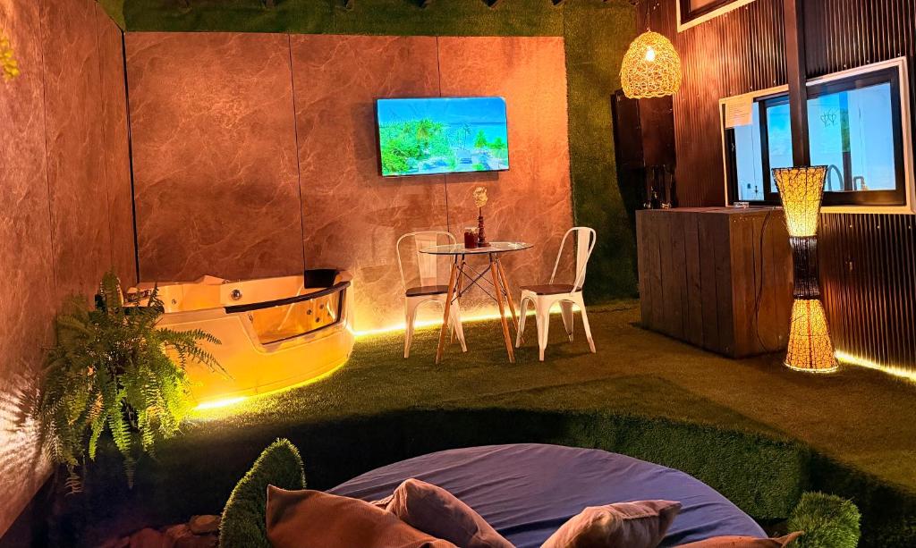 a room with a bed and a table and a tv at Casa Panal , Jacuzzi opcional Villa Alemana in Villa Alemana