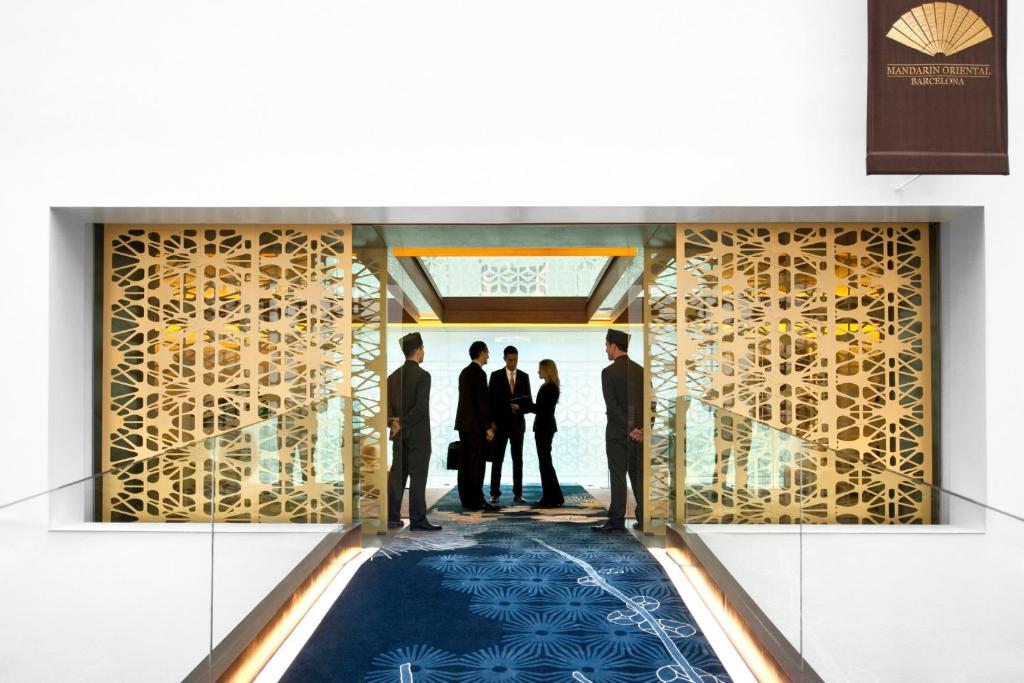 a group of four people standing in the lobby of a building at Mandarin Oriental, Barcelona in Barcelona