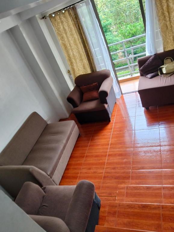 a living room with a couch and two chairs at Gigi's transient house in Baguio