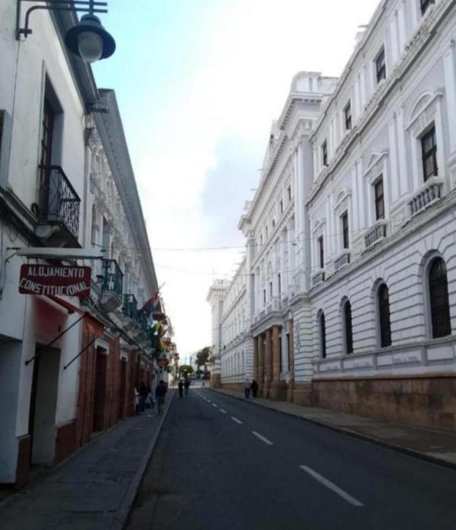an empty city street with white buildings on the side at Alojamiento hostel constitucional in Sucre