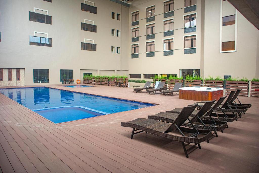 a courtyard with chairs and a swimming pool in front of a building at Aglow Hotel Harbor Bay Batam in Nagoya