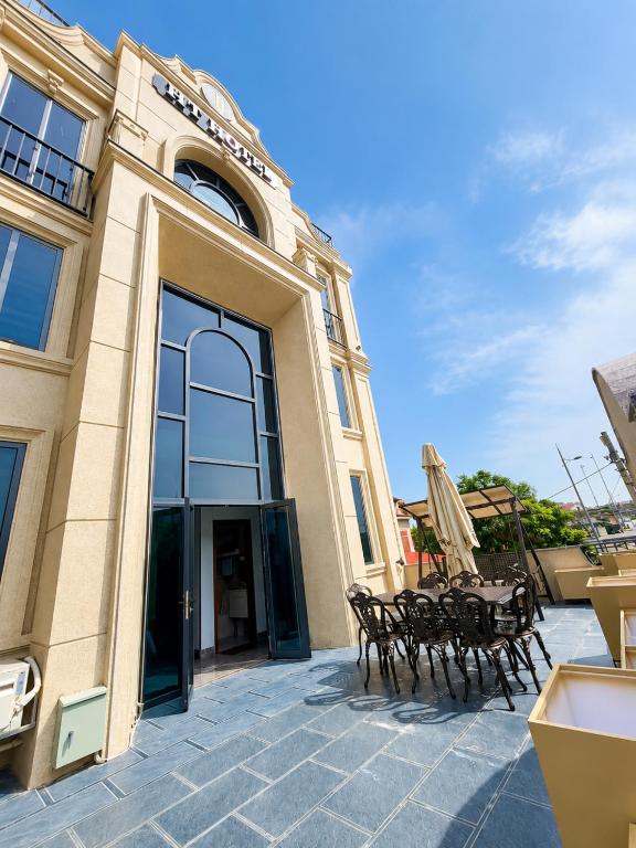 a building with two chairs and a table in front of it at HT Hotel Hà Tĩnh in Hà Tĩnh