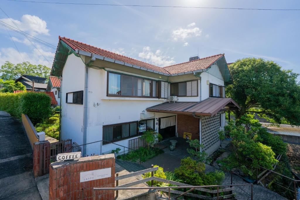 a white house with a red roof at guesthouse LAPPY in Ureshino