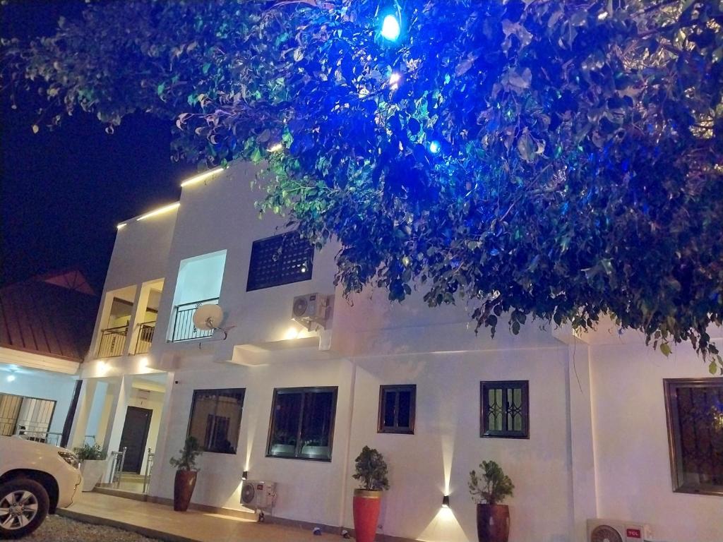 a white house with a tree in front of it at Excel Roses Hotels in Kontrajeso