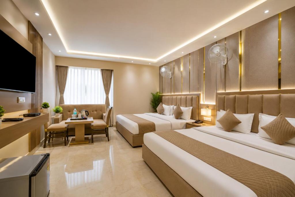 a hotel room with two beds and a television at Hotel Kelvish Plaza-Delhi Airport in New Delhi