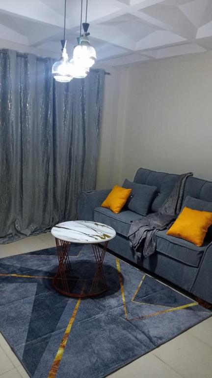 a living room with a blue couch and a table at Cess cozy stay maua in Maua