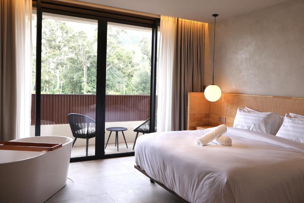 a hotel room with a bed and a balcony at By The Hill in Bukit Mertajam