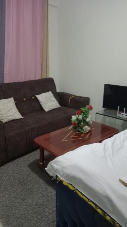 a living room with a couch and a coffee table at Cess cozy studio in Maua