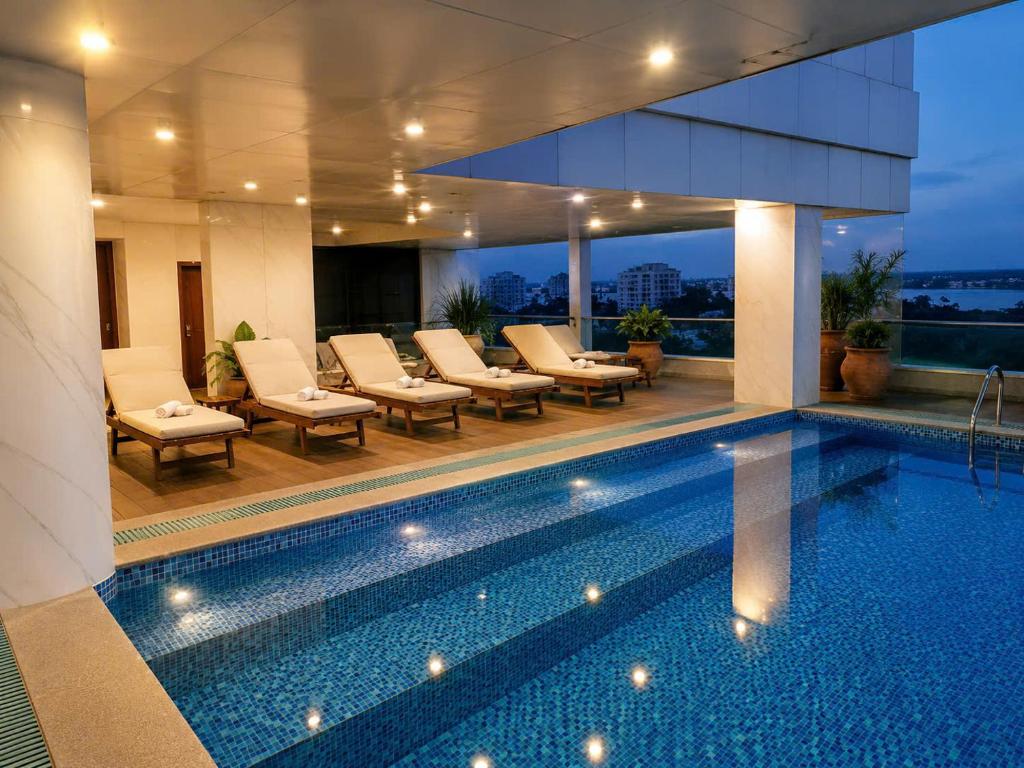 a swimming pool with lounge chairs next to a building at Khách sạn Sài Gòn Vĩnh Long in Vĩnh Long