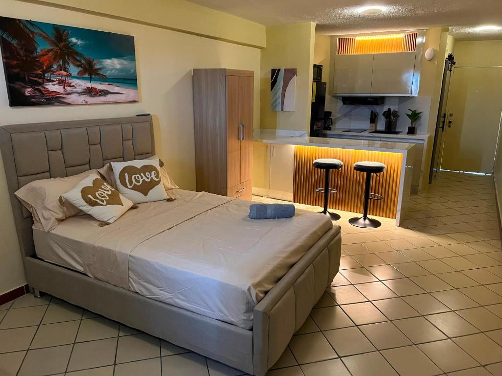 a bedroom with a large bed and a kitchen at Exclusiva suite en Hotel Marbellamar in Pampatar