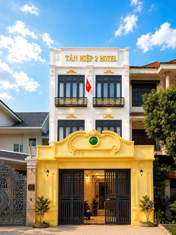 a yellow and white building with a sign on it at Tân Hiệp 2 Hotel in Bùi Tiếng