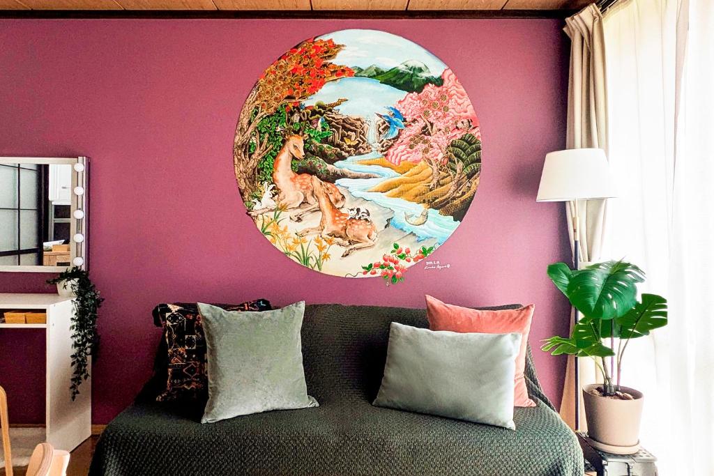 a large painting on a wall above a bed with pillows at Nikko Kanoko - Japanese Apartment near Nikko Station in Nikko