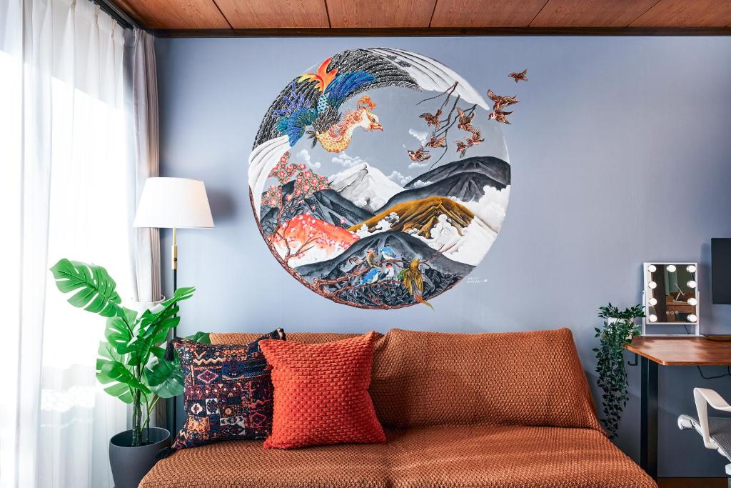 a large painting on the wall of a room with a couch at Nikko Kawasemi - Japanese Apartment near Nikko Station in Nikko