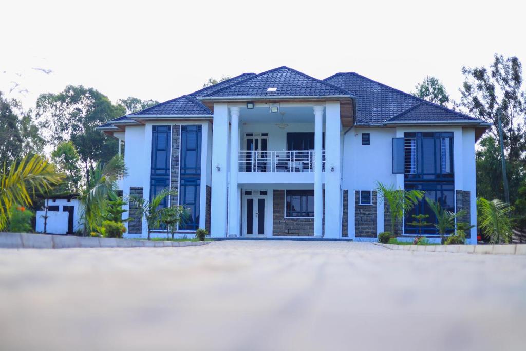 a house with blue shutters on a beach at Grato Pacho in Kisumu