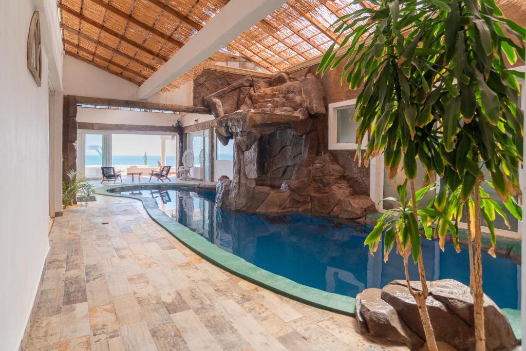 a pool in a house with a rock wall at Tortugas Bay, MX in Don Pancho