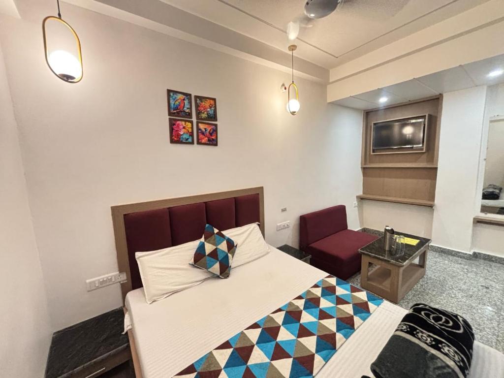 a hotel room with a bed and a chair at Luxmi Hotel in Allahābād
