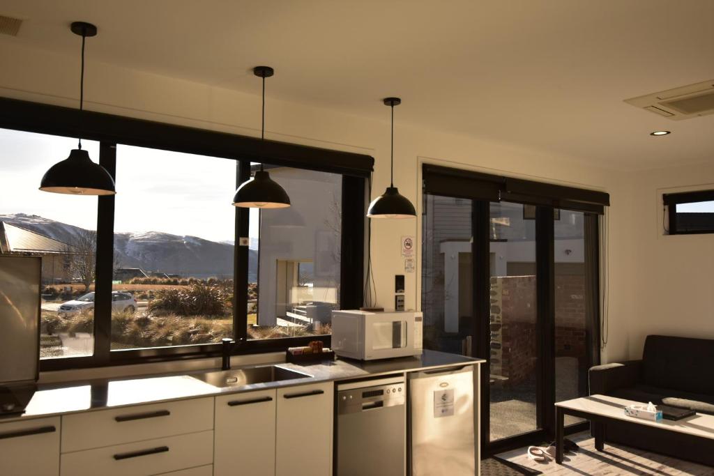 a kitchen with a large window with a view at Simply Stunning Stars B in Lake Tekapo