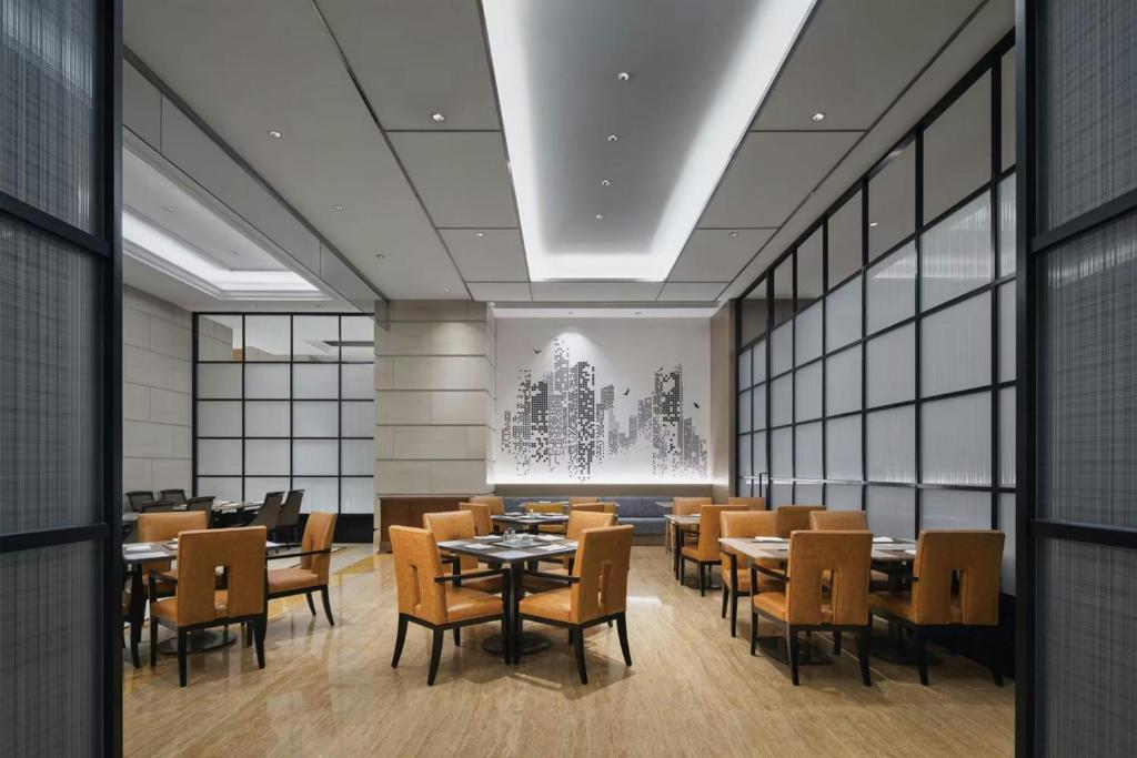 a dining room with tables and chairs and windows at Sheraton Shanghai Pudong Riverside in Shanghai
