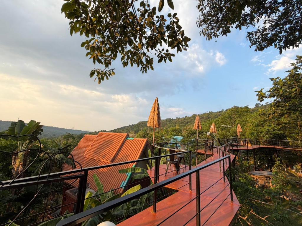 a view from the balcony of a resort with tables and umbrellas at YaithiengHill Resort ยายเที่ยงฮิลล์ รีสอร์ท in Ban Khanan Chit