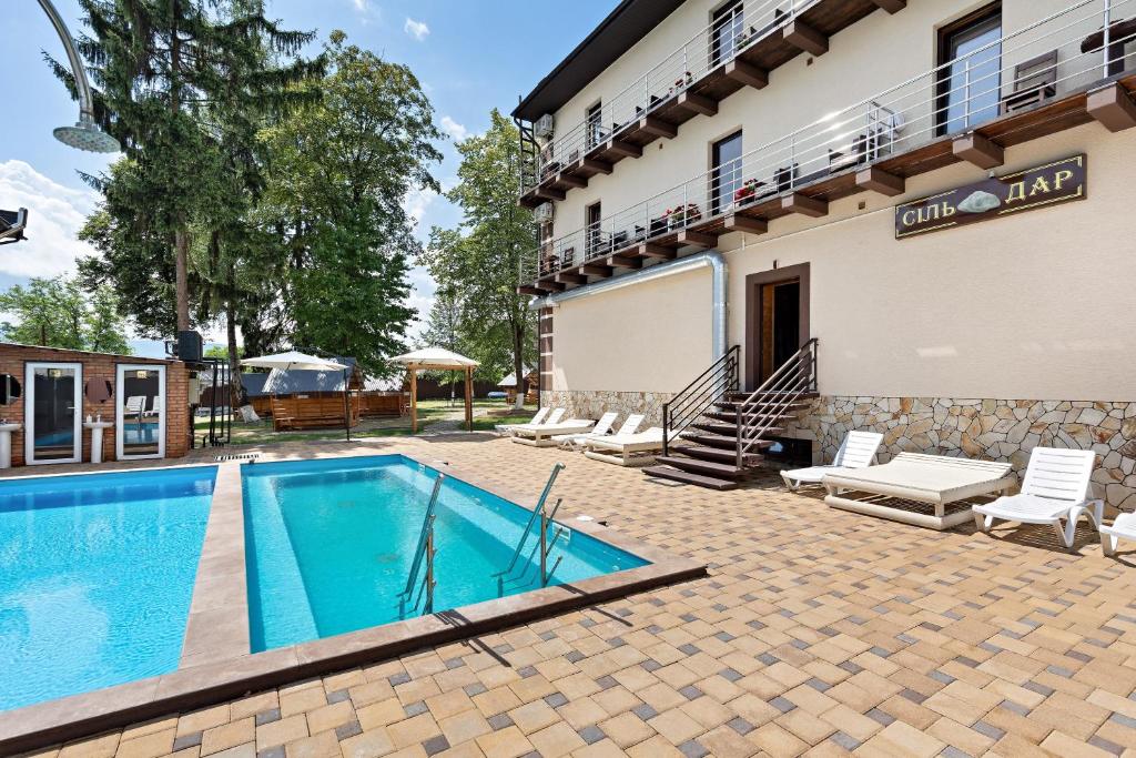 a swimming pool in front of a building at Комплекс СільДар in Solotvyno