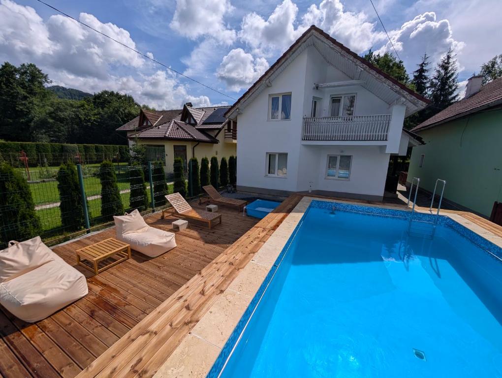 a swimming pool in front of a house at COM Home Sovata in Sovata