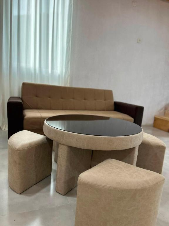 a living room with a couch and a table and two stools at Jafaridzeebtan in Oni