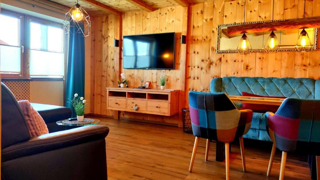a living room with a couch and a television at Ferienwohnung Zirbenduft in Inzell