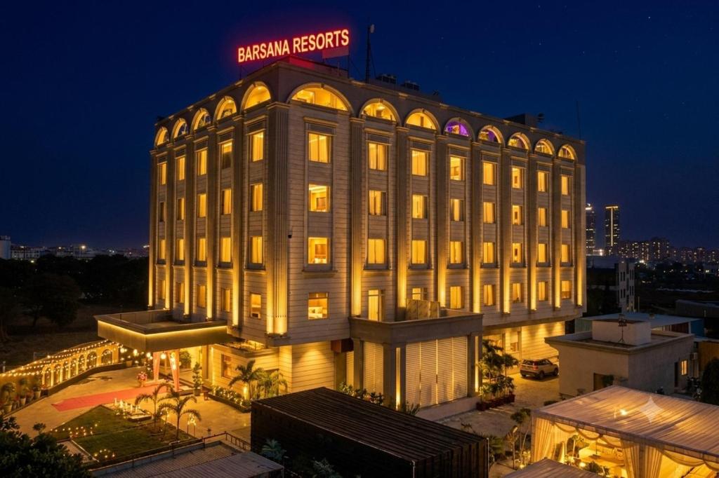 a building with a sign on top of it at night at Barsana Hotel & Resorts in Jaipur