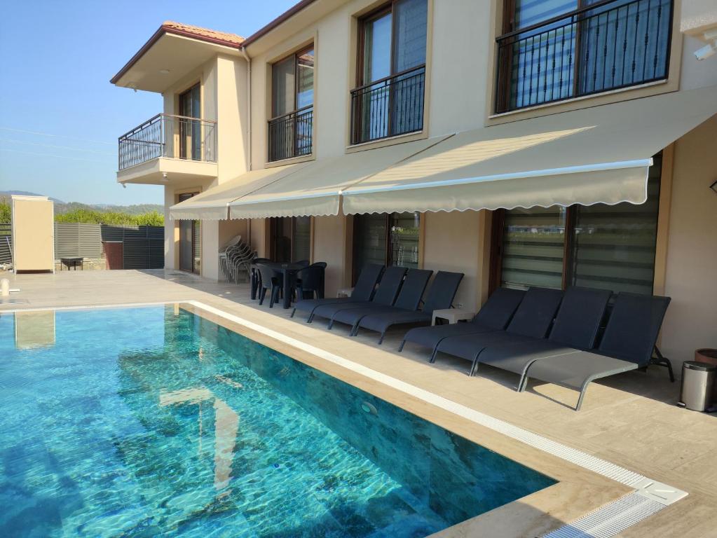 ein Haus mit Swimmingpool neben einem Haus in der Unterkunft Pronaos in Ortaca