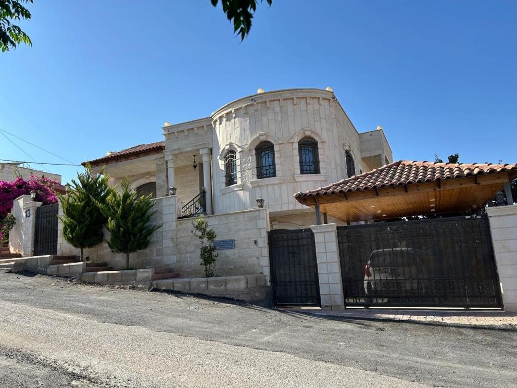 ein Gebäude mit einem Tor vor einem Haus in der Unterkunft Jerash Villa For Rental in Gerasa