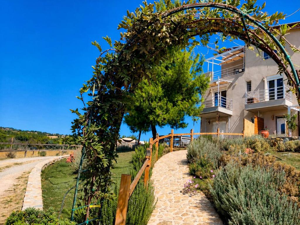 a house with an arch in front of a yard at EuZoea Country Home 2 Nature Escape with Pool in Kapandrítion