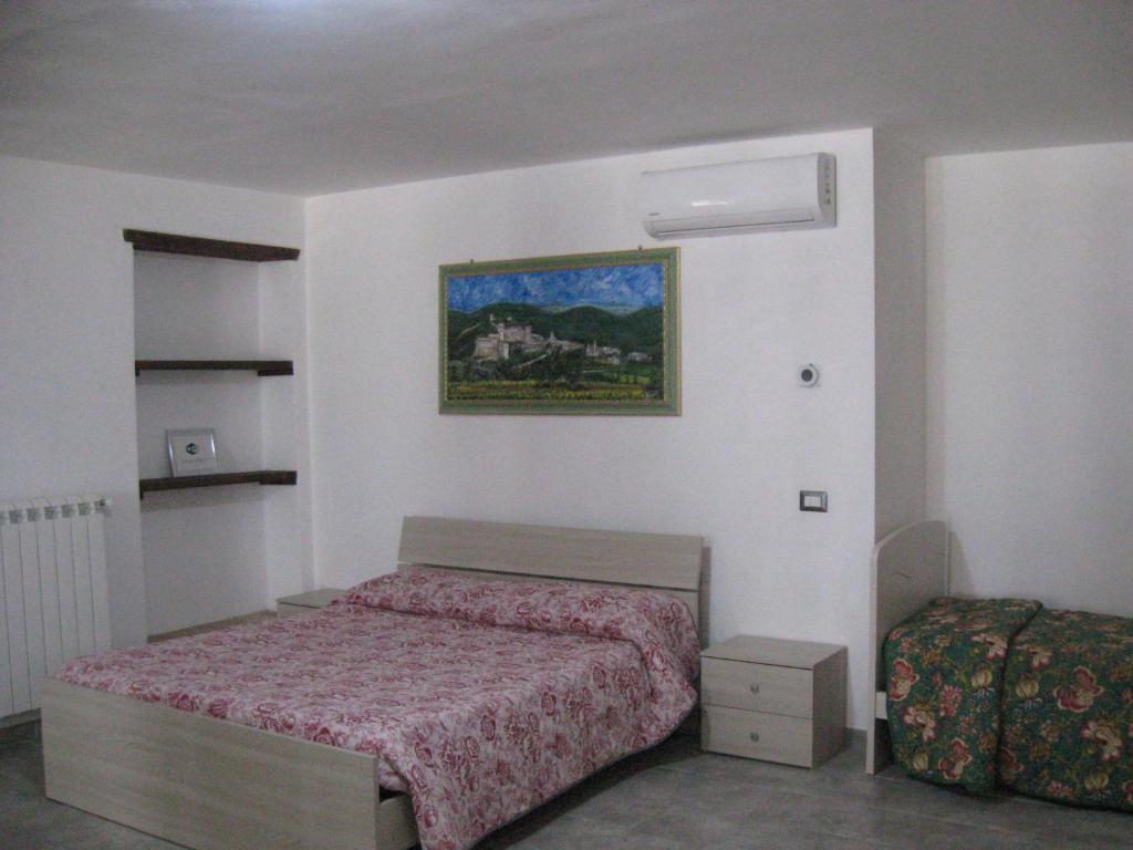 a bedroom with a bed and a picture on the wall at Appartamento open space al civico 29 in Collestrada