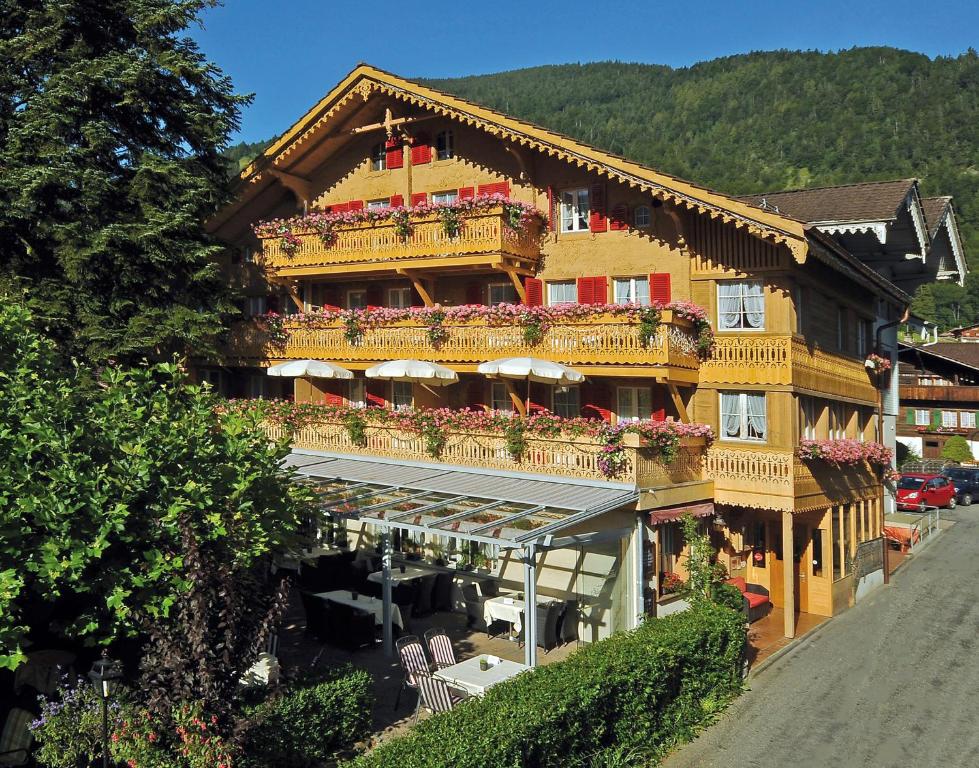 um grande edifício com varandas e flores em Alpenblick Hotel & Restaurant Wilderswil by Interlaken em Wilderswil