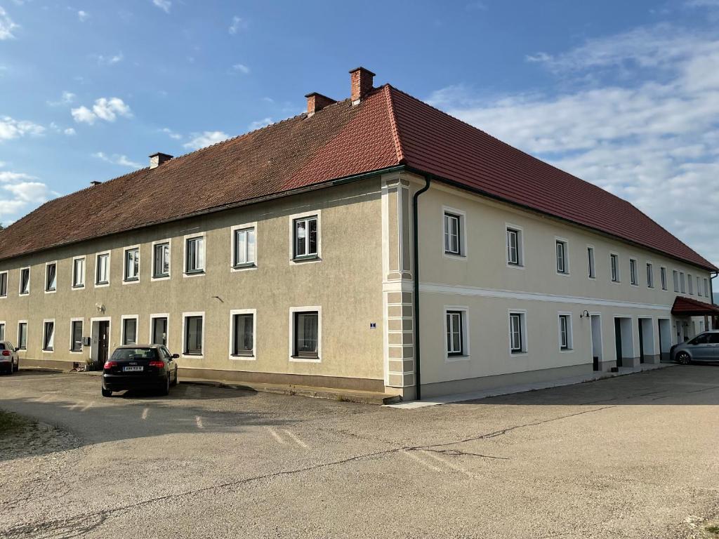 a large white building with a red roof at Gästezimmer am Bauernhof in Behamberg