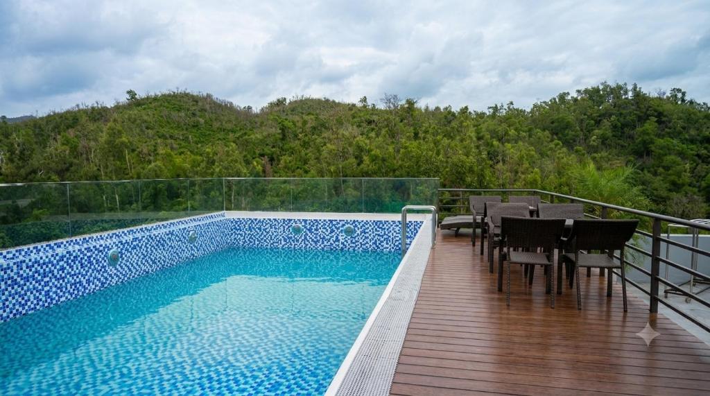 a balcony with a swimming pool and a table and chairs at Horizon Minh Chau Hotel in Quang Ninh