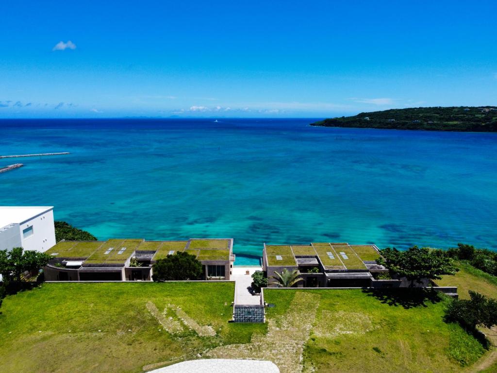 an aerial view of a house with the ocean at KAYATSUMA OKINAWA Hotel&Resort in Nakijin