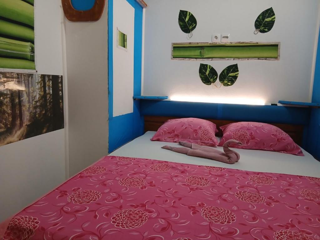 a bedroom with a pink bed with pink pillows at Apartman Retro 2 in Žepče